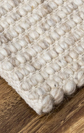 White rug, hand woven on timber flooring