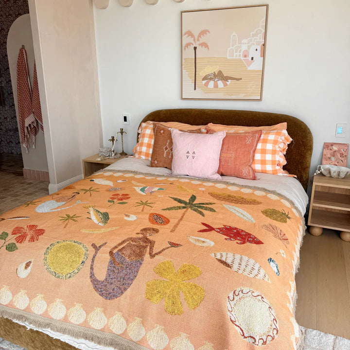 Bedroom with a bed featuring a colorful quilt and pillows, decorated with a wall art piece.