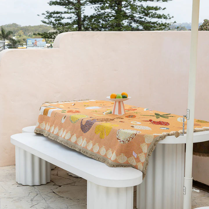 Outdoor setting with a table, bench, and striped umbrella on a patio.