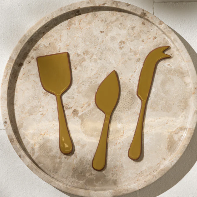 Decorative stone tray with gold cutlery icons on a light background