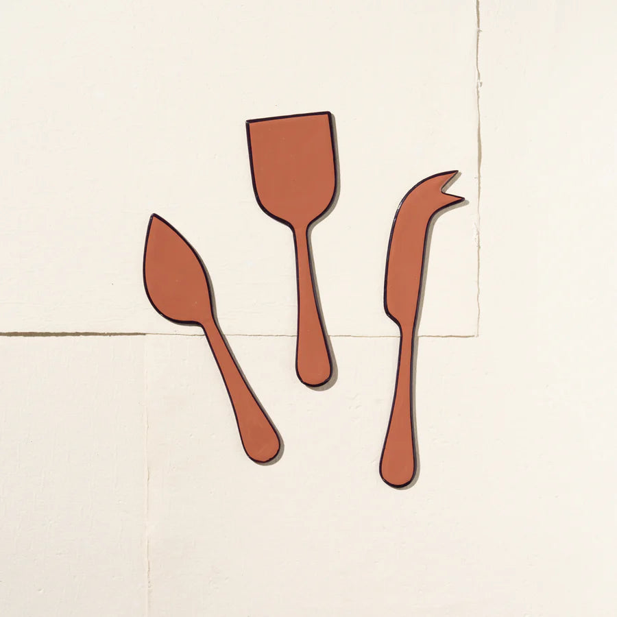 Set of three wooden utensils on a light beige background