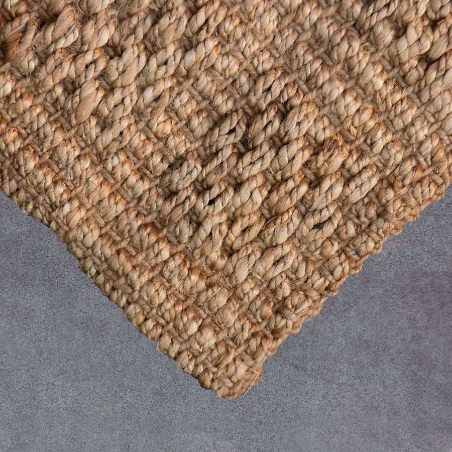 Close-up of a textured woven mat on a gray surface