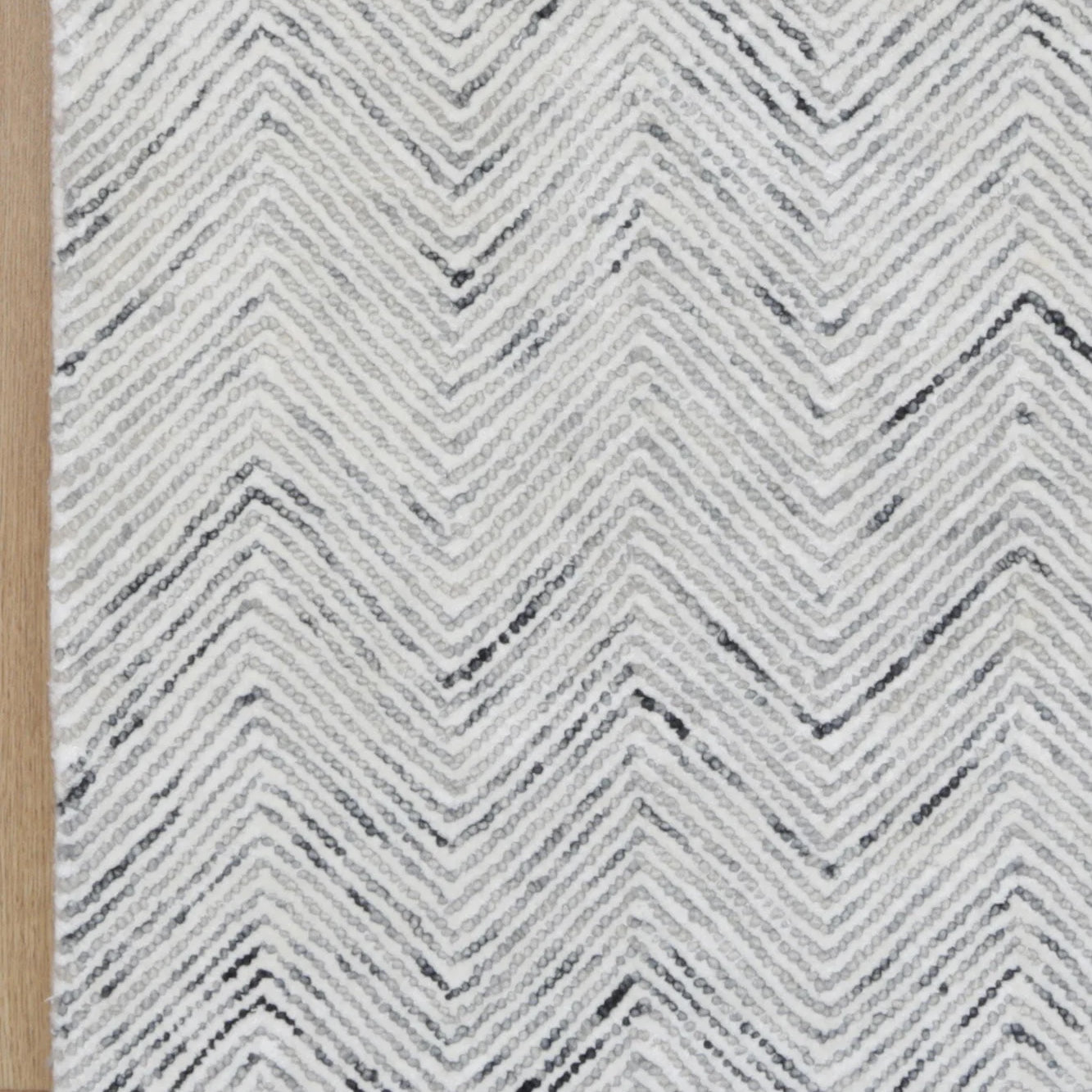 Detailed close-up of the Astrid Grey Rug's herringbone texture, emphasizing the luxurious blend of wool and viscose.