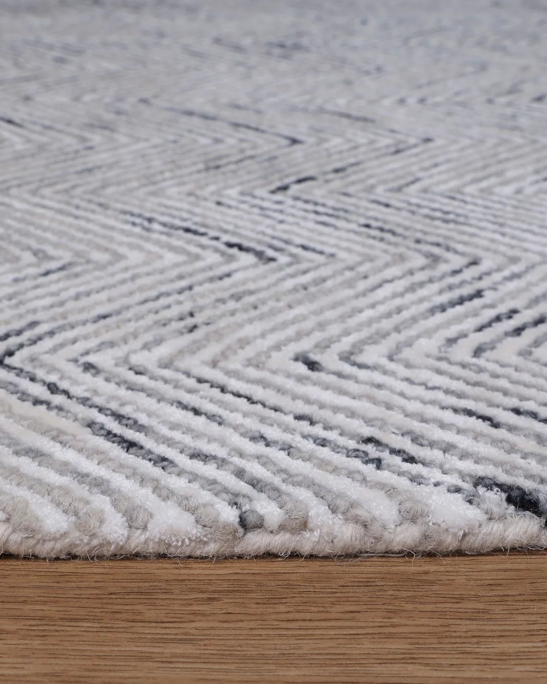 Zoomed-in view of the Astrid Rug's unique braided loop and viscose cut pile, highlighting the artisanal craftsmanship.