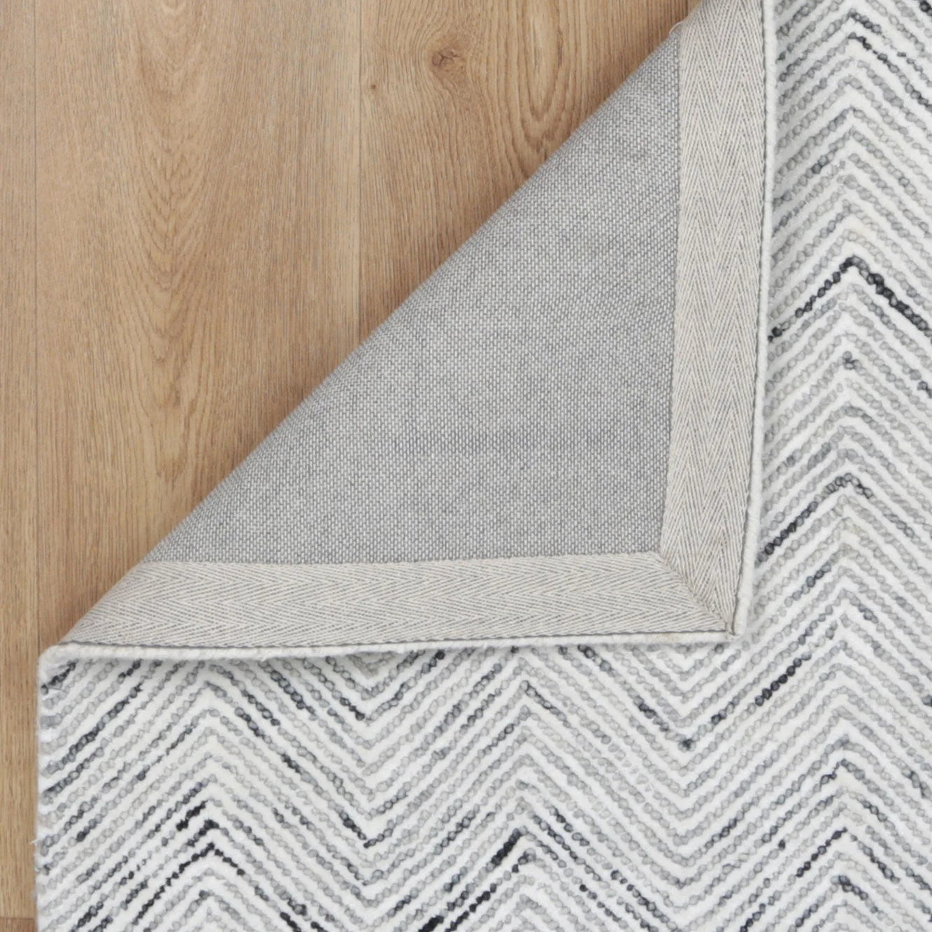 Astrid Herringbone Grey Rug elegantly placed in a contemporary room, accentuating its versatility and sophisticated design.