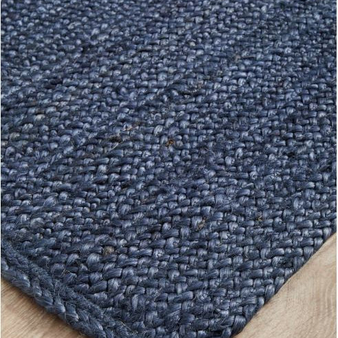 Close-up of a blue textured rug on a wooden floor