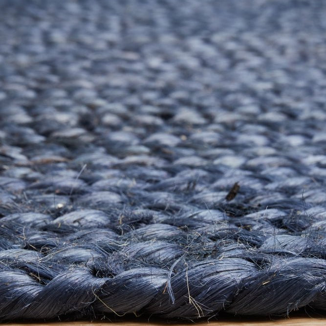 Close-up of a textured blue rug on a wooden floor