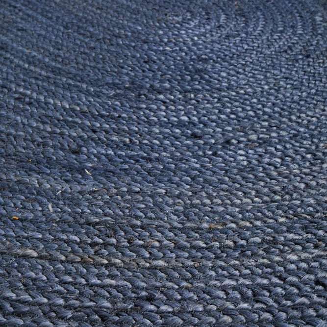 Close-up of a textured blue rug on a wooden floor