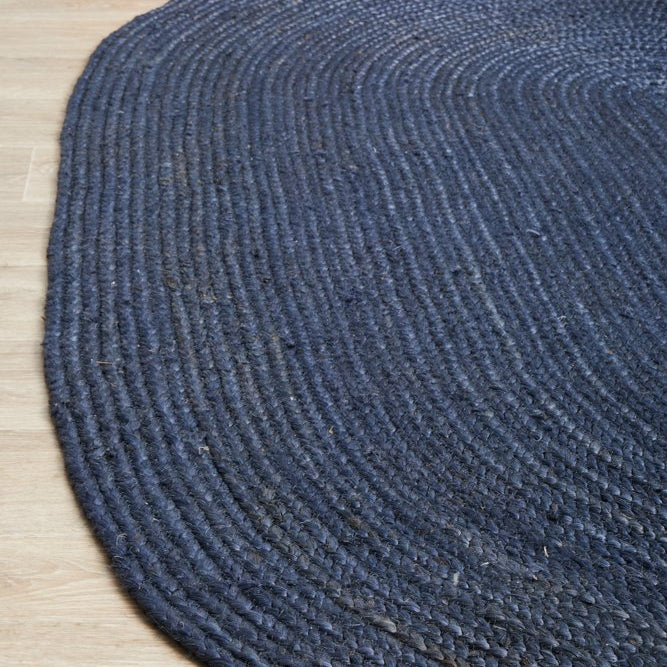 Round blue braided rug on a wooden floor