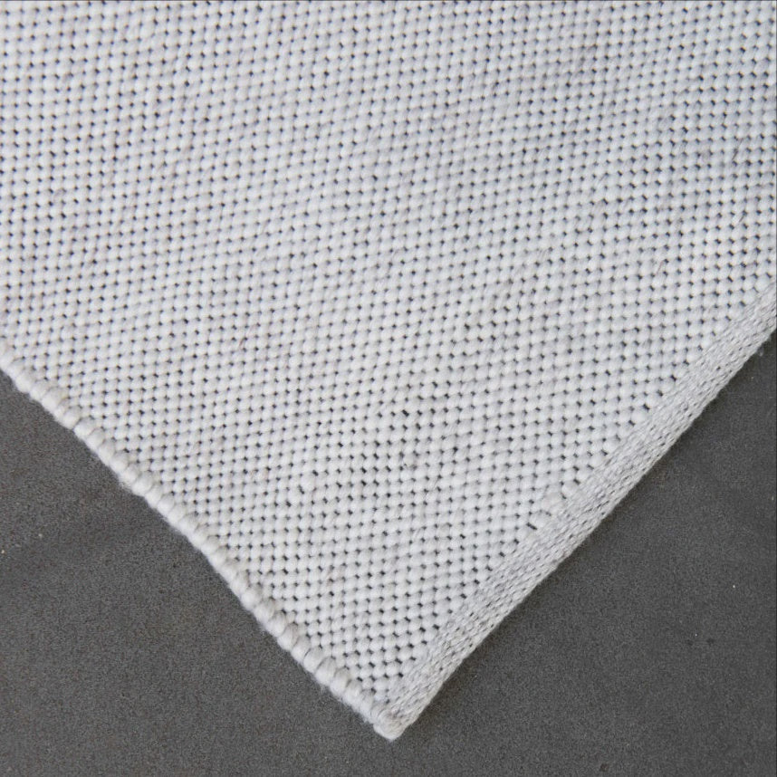 Close-up of a textured gray fabric corner on a dark background