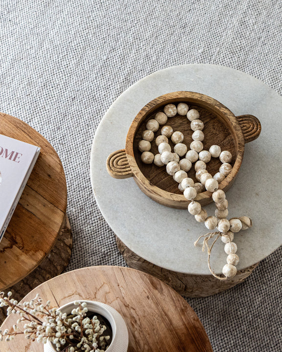 Decorative items on a marble and wooden surface with a magazine.