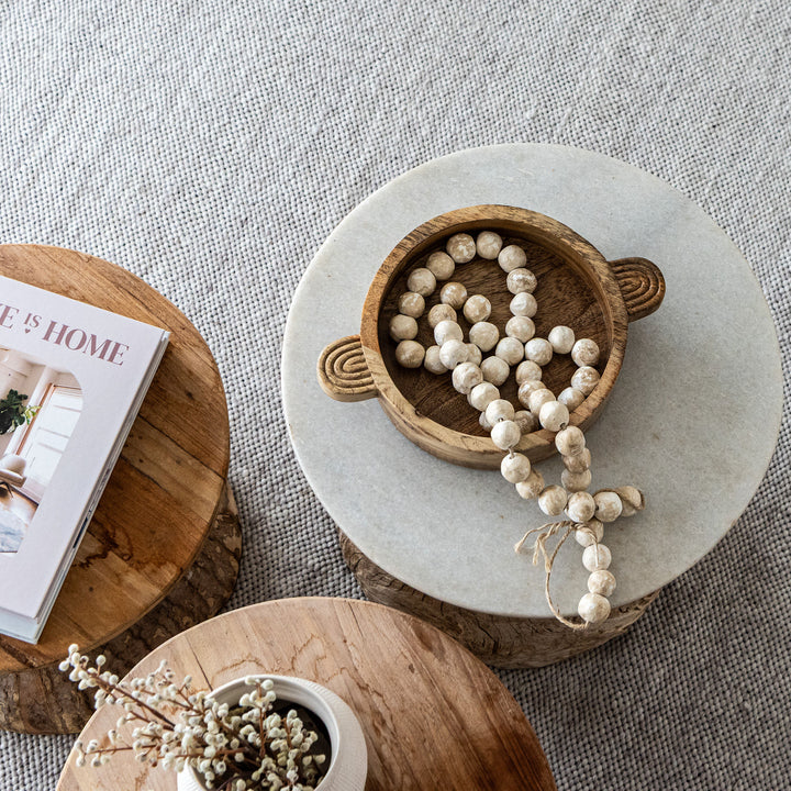 Decorative items on a marble and wooden surface with a magazine.