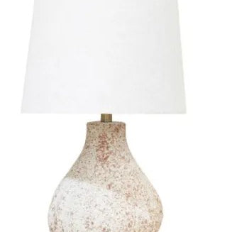 A table lamp with a textured, speckled beige and white ceramic base and a large white fabric drum shade, shown against a plain white background.
