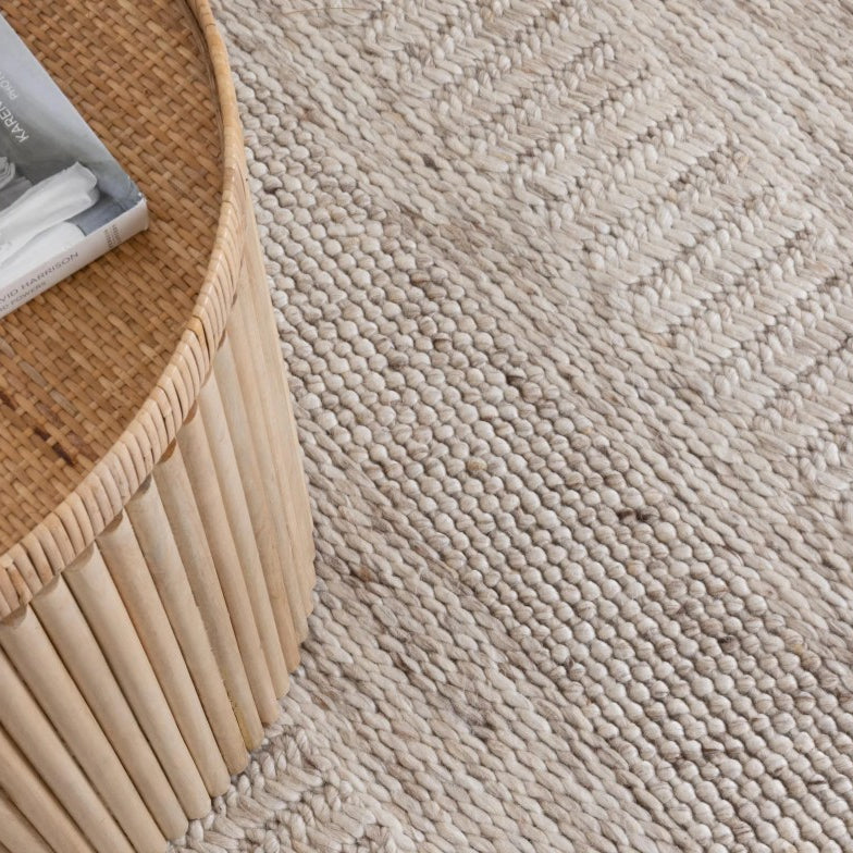 Close-up of a textured beige carpet with a woven pattern.