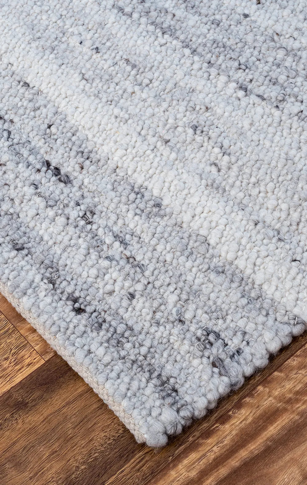 Gray textured rug on a wooden floor