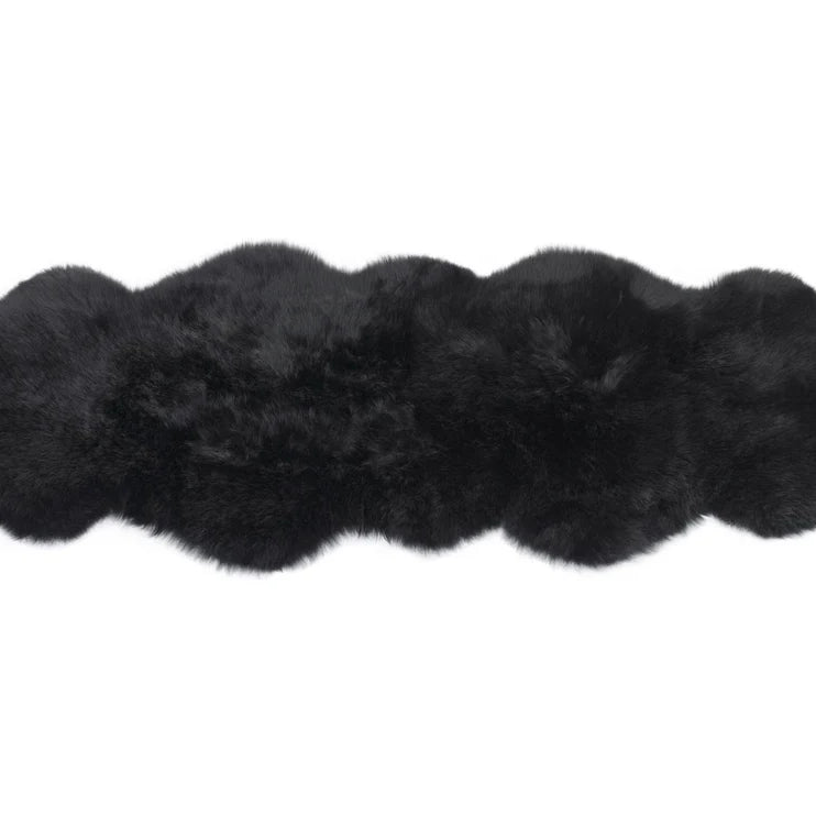 Black double sheepskin rug on a white background