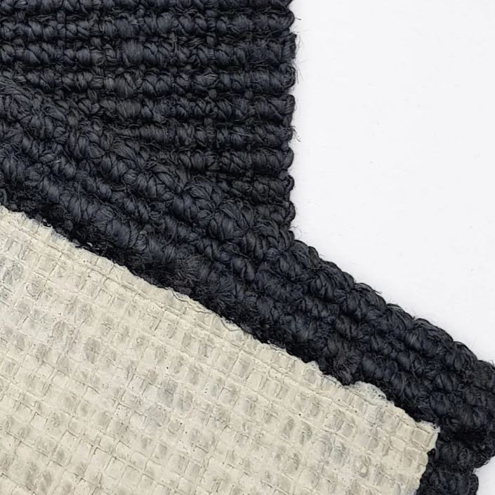 Close-up of textured black and beige rugs on a white background