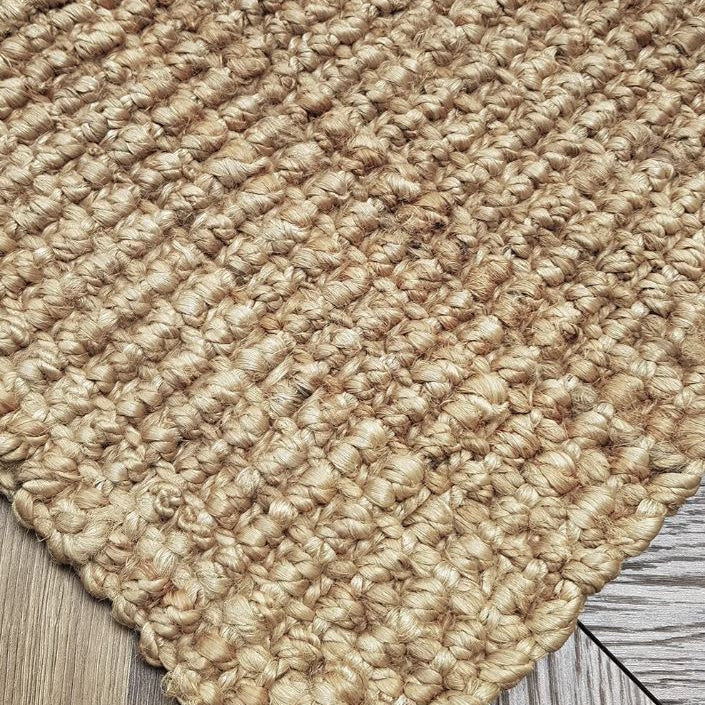 Close-up of a textured beige rug on a wooden floor