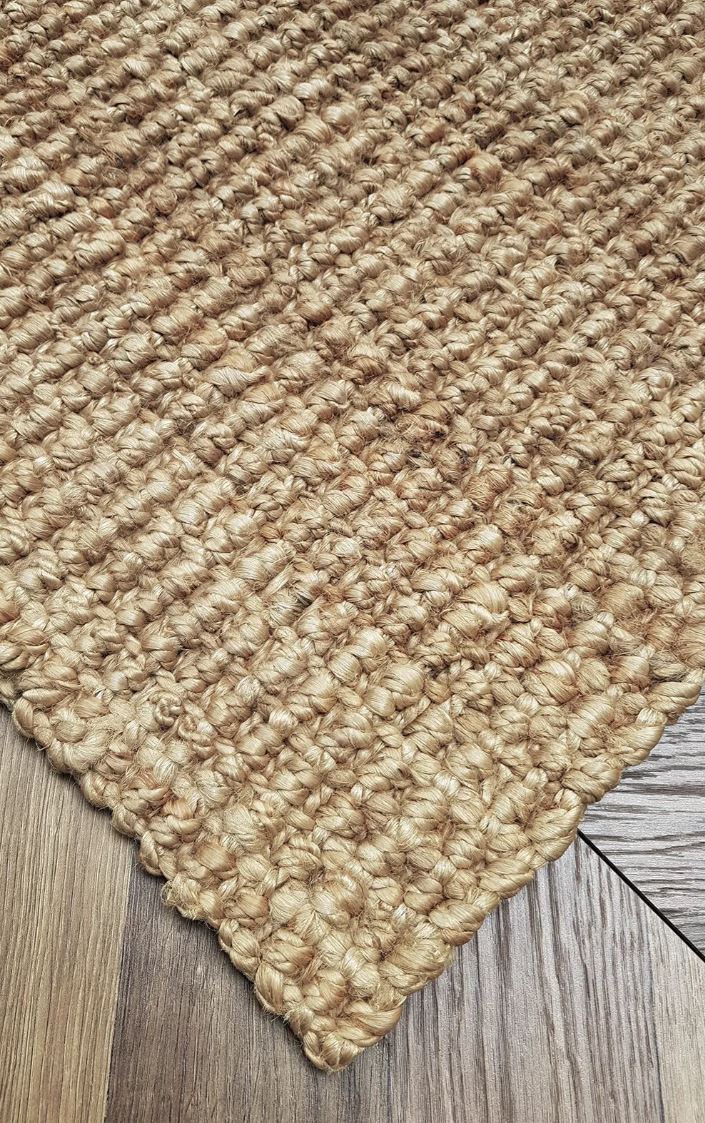 Close-up of a textured beige rug on a wooden floor