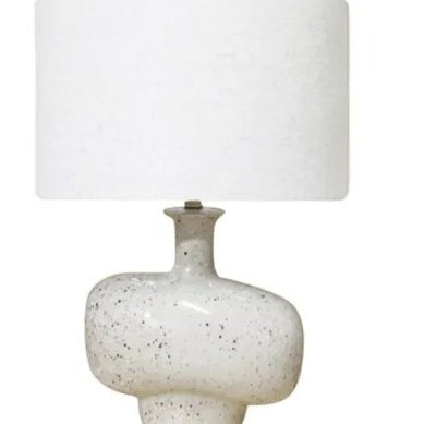 Table lamp with a white ceramic base and white shade on a white background