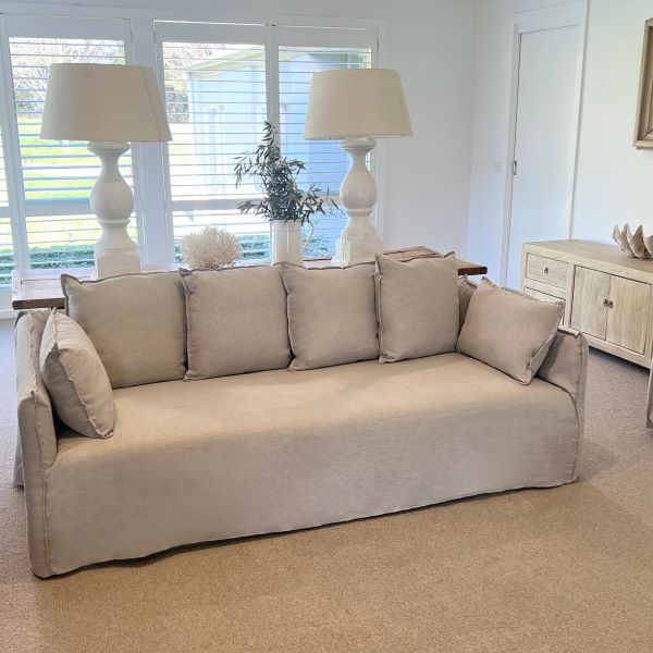 Beige sofa in a living room with lamps and decor