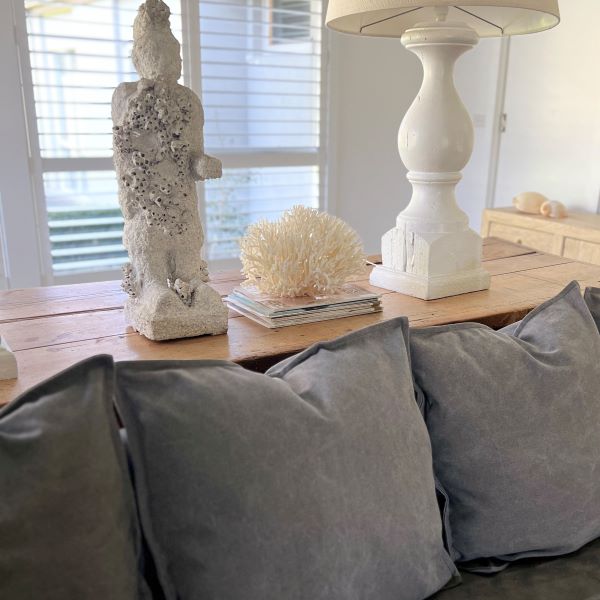 Decorative items on a table with gray cushions in the foreground