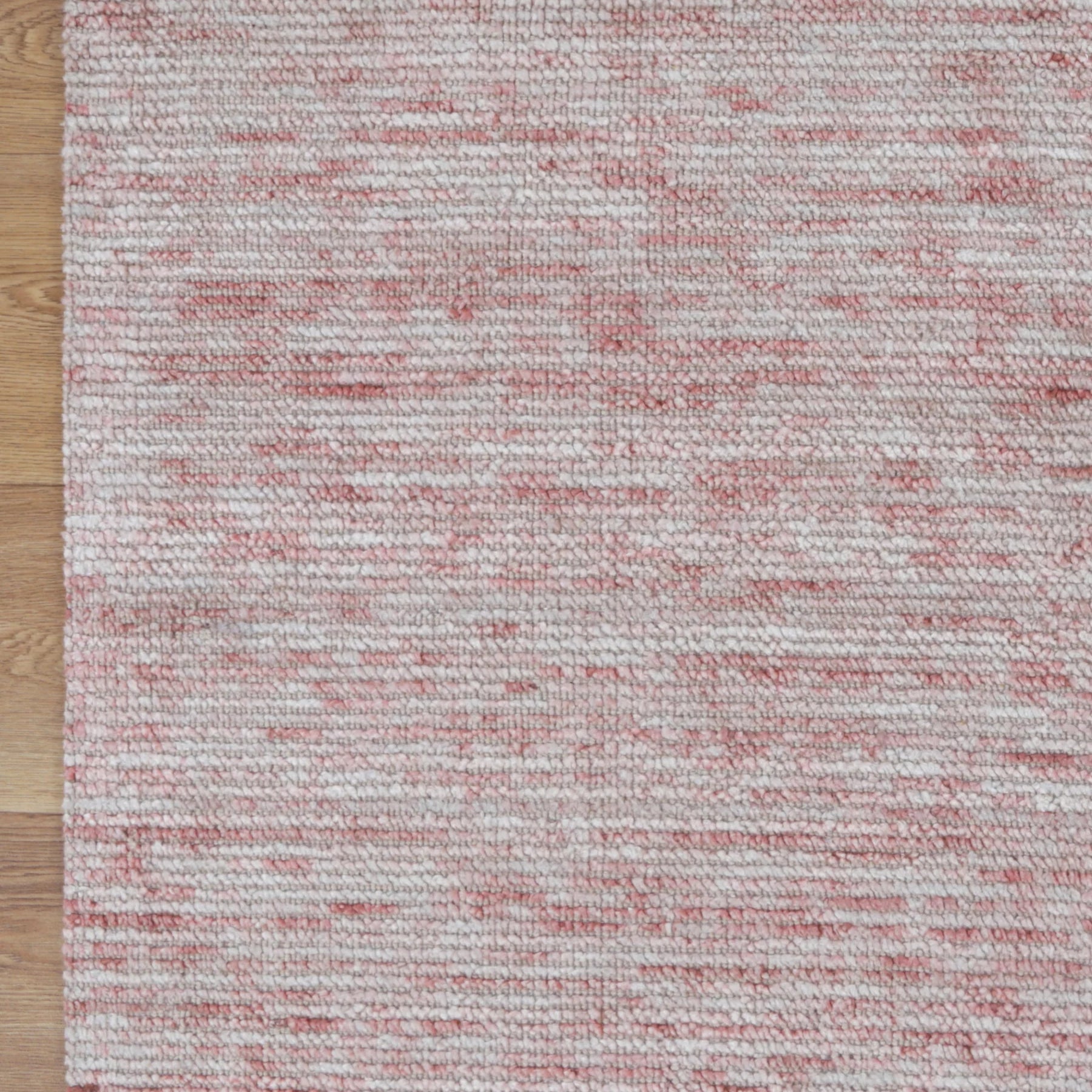 Textured red and gray area rug on a wooden floor