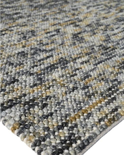 A mid grey, handwoven, textural rug with varying shades and a heavy quality appearance.