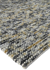 A mid grey, handwoven, textural rug with varying shades and a heavy quality appearance.