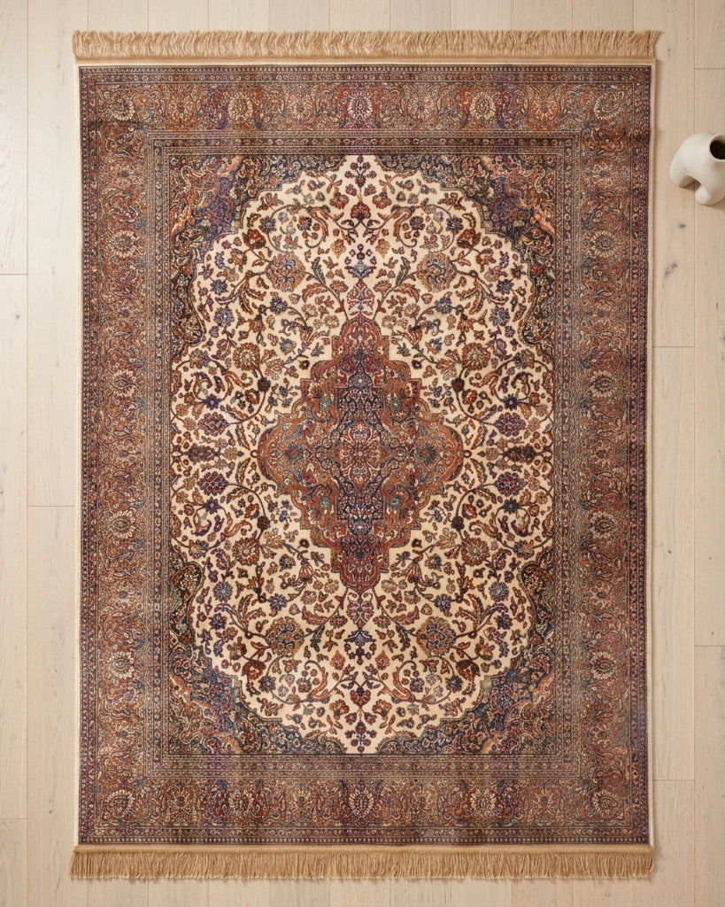An ornate traditional area rug with a central medallion and intricate floral patterns, displayed flat on a light wood plank floor next to a small white wall-mounted vase.