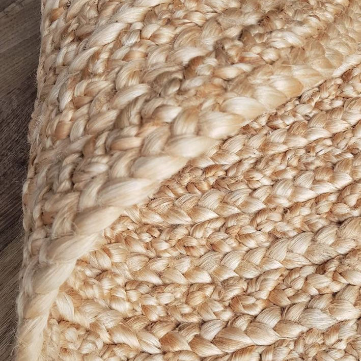 Close-up of a braided beige rug on a wooden floor
