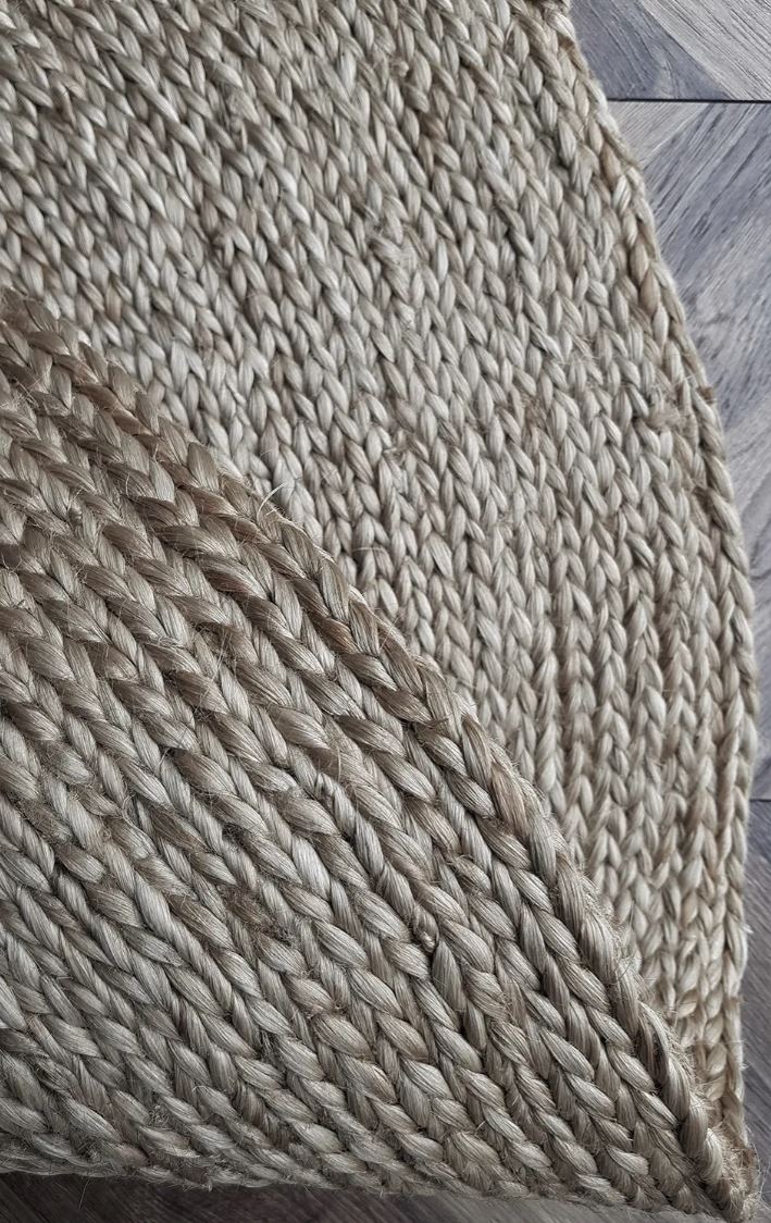 Close-up of a textured beige rug on a wooden floor