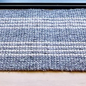 Textured gray doormat on a wooden floor