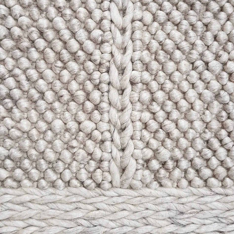 Close-up of textured beige carpet with a woven pattern