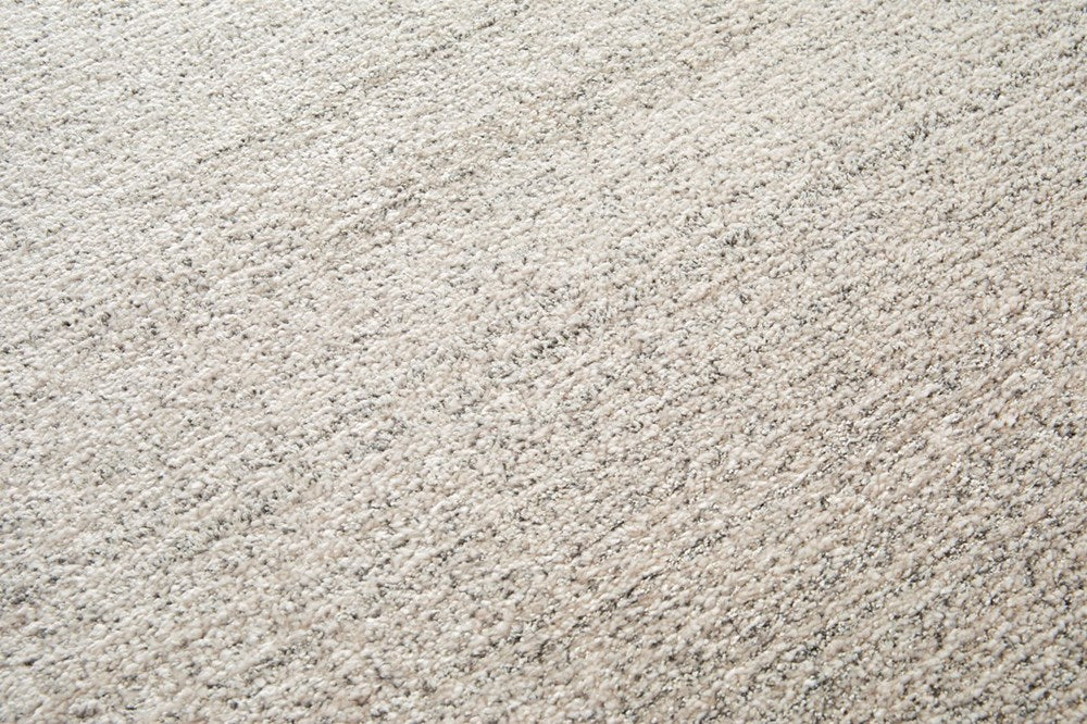 Detailed close-up of the Cumulus Rug's Stone-colored texture, emphasizing its soft polypropylene material and subtle color contrasts.