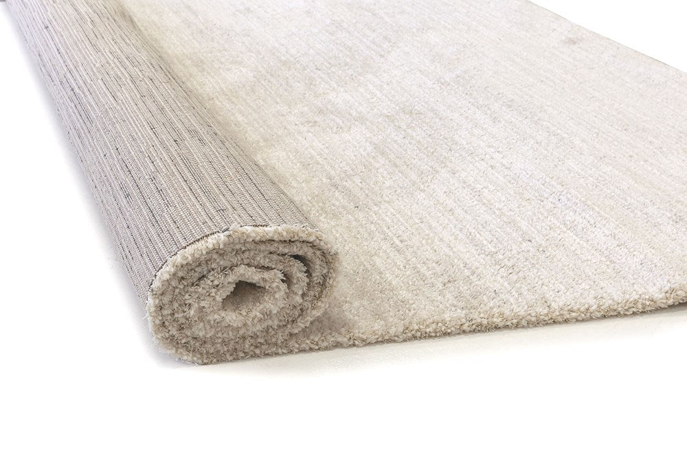 Roll of beige carpet on a white background