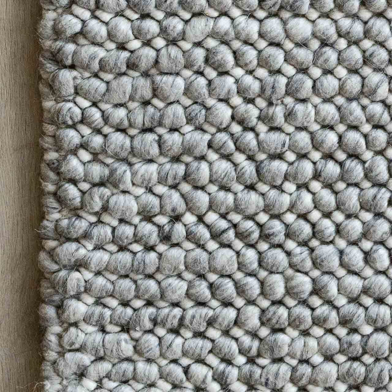 Textured gray rug with a pattern on a wooden floor
