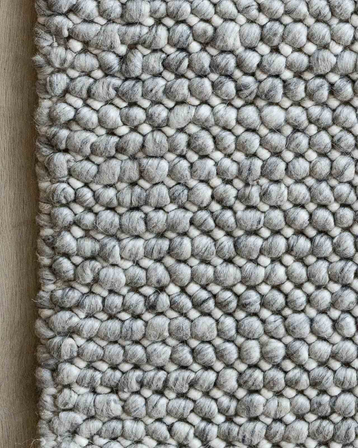 Textured gray rug with a pattern on a wooden floor
