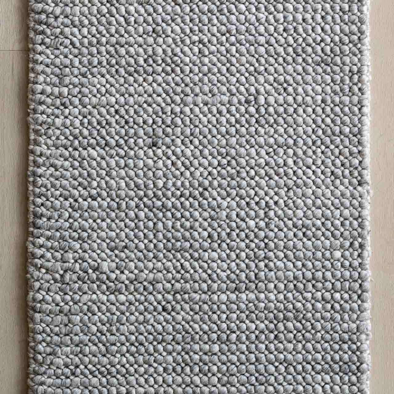 Textured gray rug on a wooden floor
