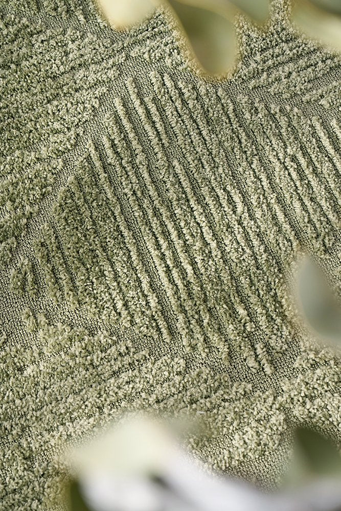 Close-up of a textured green fabric with a subtle pattern