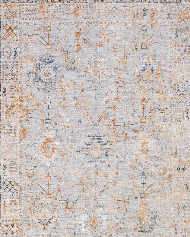 A distressed traditional area rug featuring a faded light gray base with intricate patterns in muted orange, beige, and soft blue.