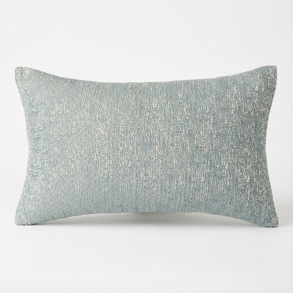 A rectangular lumbar throw pillow in a textured, woven fabric with a mottled pattern of light blue and off-white threads, shown against a plain white background.