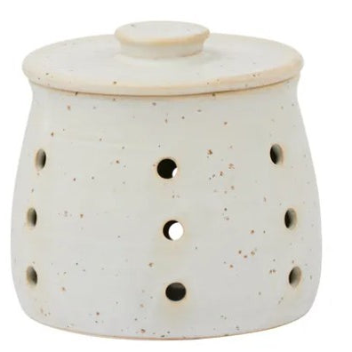White ceramic oil burner with holes and a lid on a white background