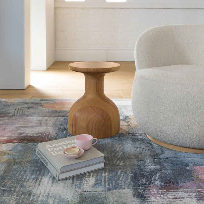 Living room with a textured rug, wooden side table, and gray armchair, featuring the brand 'Franklin'.