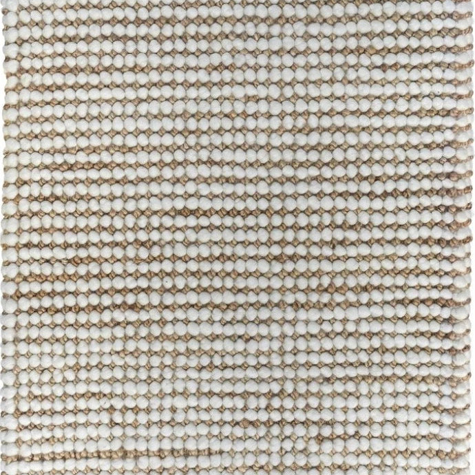 Focusing on the hand-woven details, this image captures the skilled craftsmanship of the rug and the striking contrast between the natural jute and white wool, illustrating the rug's quality and aesthetic appeal.