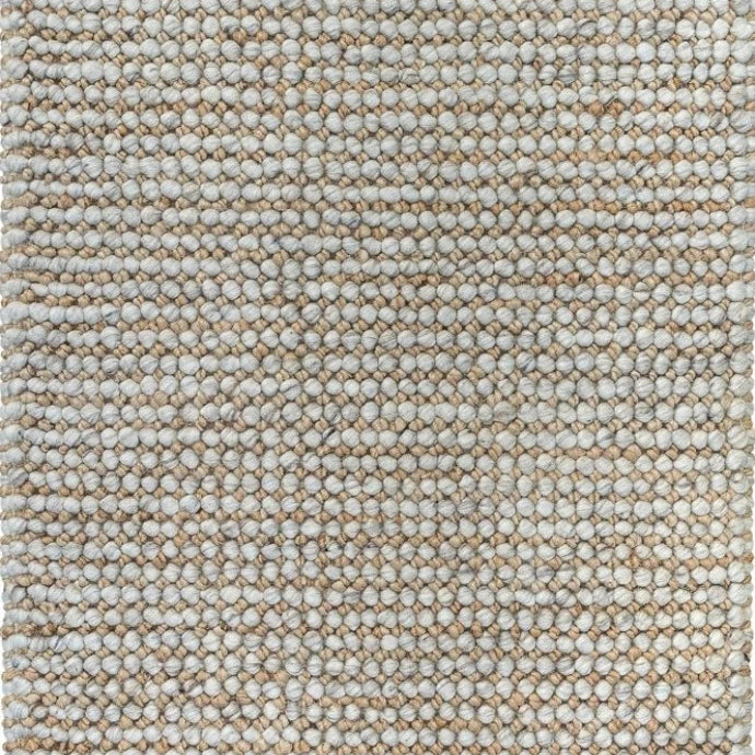 This image focuses on the fine details of the rug, highlighting the interplay between the natural and silver colors, and showcasing the unique texture created by the blend of wool and jute.