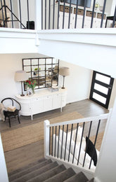 Staircase with a small sitting area and decorative items in a home interior.