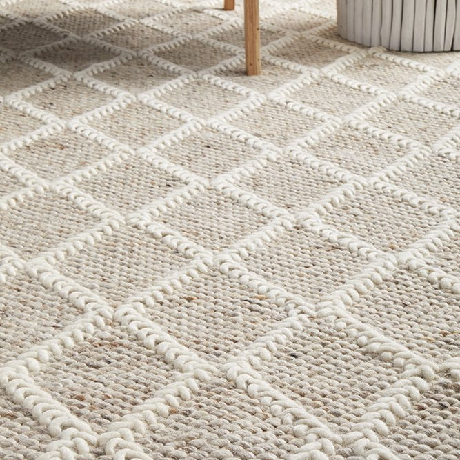 Textured area rug with geometric pattern on wooden floor
