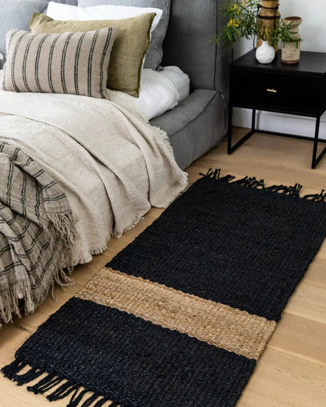 Bedroom with a black and beige rug on wooden flooring