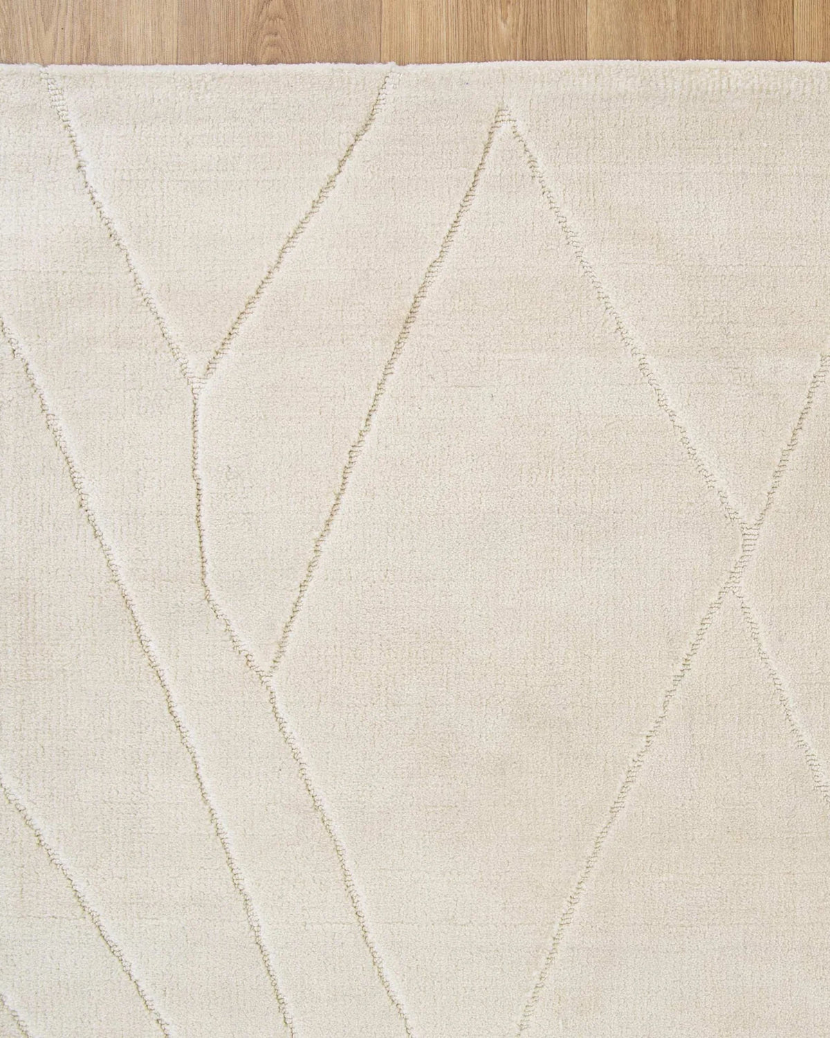 Beige rug with geometric pattern on a wooden floor